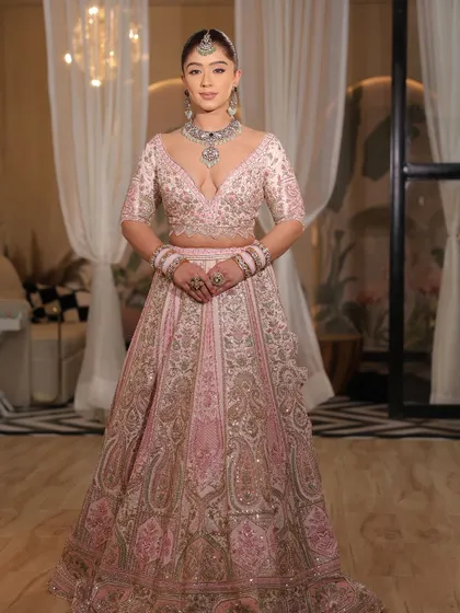 A close-up of the modern pink bridal lehenga. The plunging neckline and the intricate embroidery make it a bold and beautiful choice.