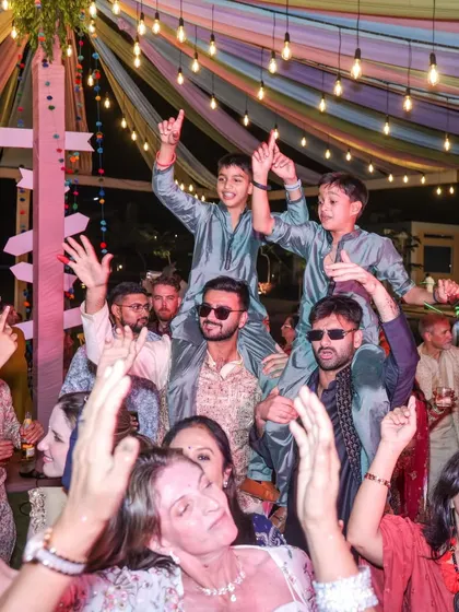 The Sangeet is a night of pure celebration. The couple and their guests enjoy the performances under a canopy of colorful drapes and lights, a signature of the vibrant events we plan.