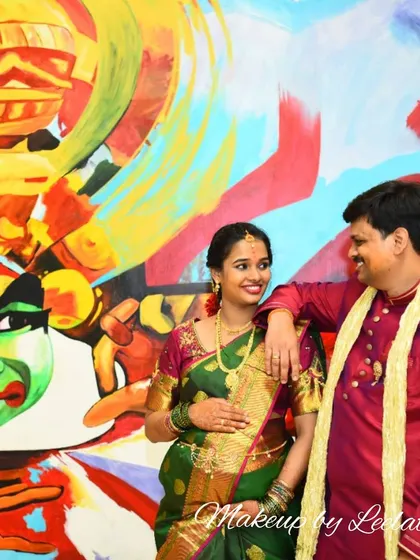 A creative portrait of a couple at their Shrimantha celebration. The expectant mother's makeup is soft and beautiful, complementing the artistic backdrop.