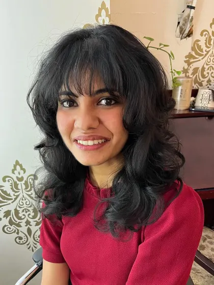 The bangs and layers create a soft, face-framing effect.