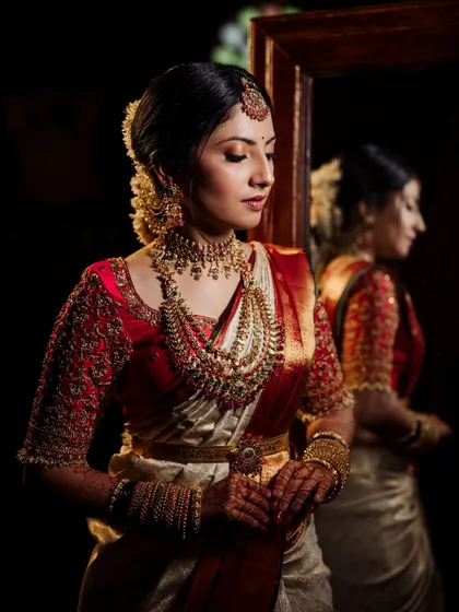 A bride looks at her reflection in a mirror, a classic and introspective shot taken in one of our antique-filled rooms.