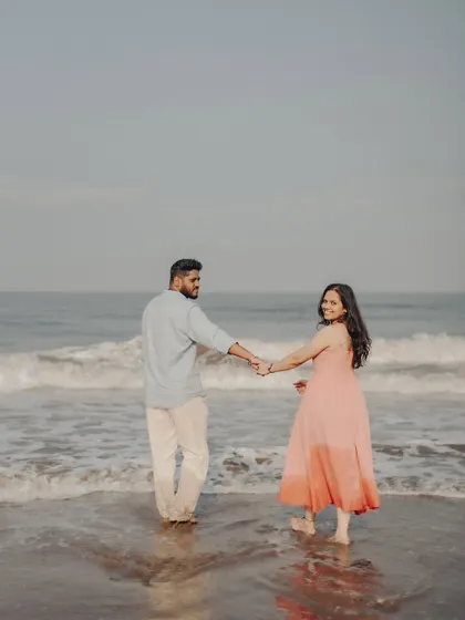 A candid moment from Anushka and Manu's beach pre-wedding session. This relaxed, "follow me" style captures the joy and movement of their connection against the ocean waves.
