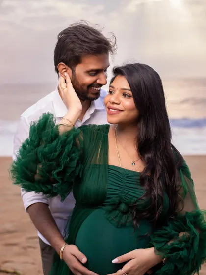 The genuine smiles and gentle touch in this portrait showcase the deep connection and shared happiness of the parents-to-be.