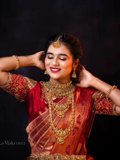 Feel like a queen on your special day. This photo shows the complete rental set, including the haram, choker, oddiyanam, and bangles, against a rich red saree.
