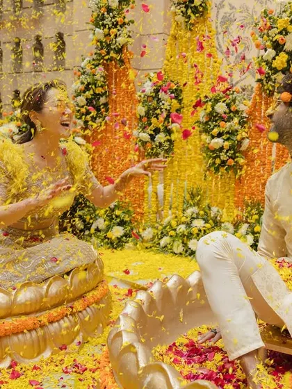 The Haldi ceremony should be filled with joy and laughter. I create vibrant, playful settings where couples can relax and share candid moments, like this one amidst a shower of colorful flower petals.