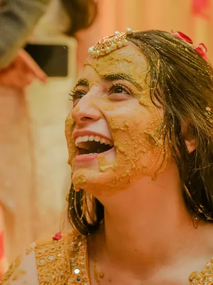The joy on a bride's face says it all. This close-up of Archie during her Haldi ceremony captures her infectious laughter, a moment of pure happiness surrounded by her loved ones.