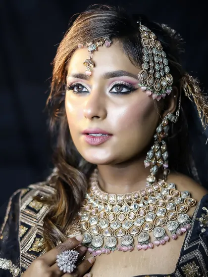 The side profile highlights the intricate hair jewelry and the contour of the cheekbones. Our training covers all aspects of bridal beauty.