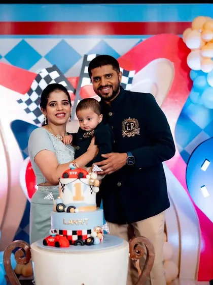 A sweet family portrait from Lakhit's "Fast One" racing party, posing with the themed cake.