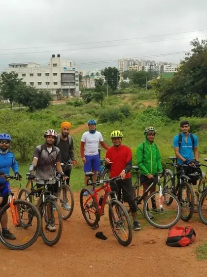 The group ready to set off from a dirt path, with a mix of urban and natural scenery in the background.