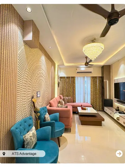 A vibrant living room featuring a stunning 3D textured wall panel as the centerpiece. The combination of a pink L-shaped sofa and turquoise armchairs creates a playful yet elegant contemporary look.