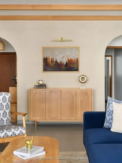 After: We introduced elegant arches, ceiling rafters, and a light beige texture paint to create a theatrical and harmonious living space with a modern cottage vibe.