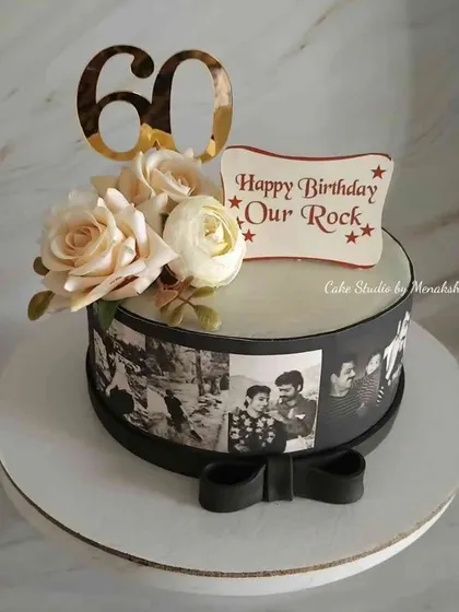 A 60th birthday cake celebrating "Our Rock." This design features a monochrome photo reel of memories, topped with fresh roses for an elegant and personal touch.