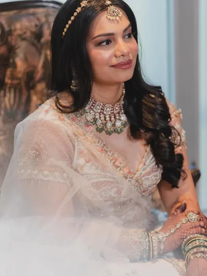 A beautiful portrait of the bride in her stunning white lehenga. The makeup is soft and minimal, with a pop of lip color to tie the look together.