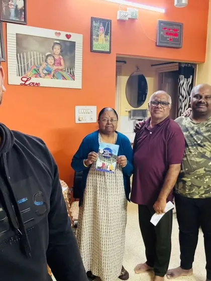 Our team with a family, holding our solar information packet.