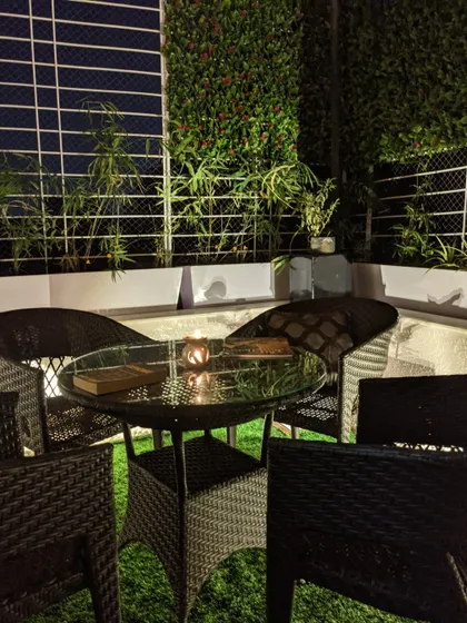 This is the feeling I aim to create: a quiet moment of peace after a long day. The warm glow from the candle on the wicker table, surrounded by the soft textures of the vertical garden and turf, makes this balcony a perfect nighttime oasis.