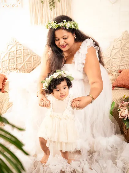 A mother helps her little one take a few steps, a beautiful moment captured during their family session.
