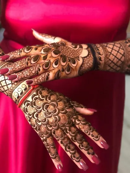 This design showcases two different but complementary styles. One hand features a peacock feather pattern, while the other has a dense floral design, showing our versatility.