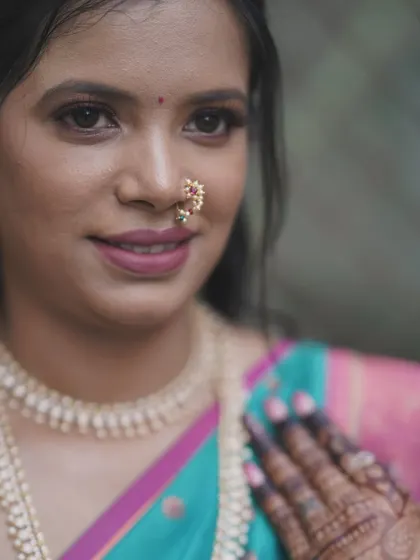 A detailed shot focusing on the eye makeup and lip color. The tones are chosen to enhance the bride's natural beauty and complement her saree.