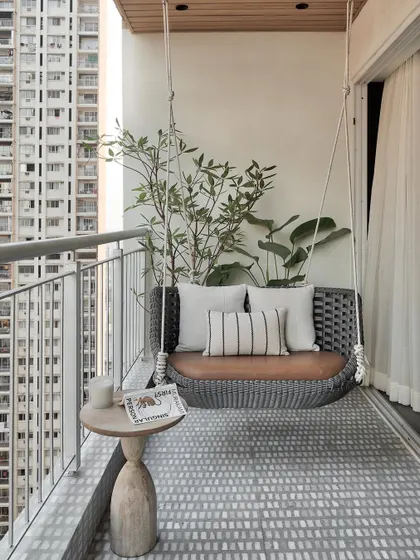 This serene balcony is a personal oasis amidst the vibrant Mumbai cityscape. The elegant cement-finish floor, with its calming shades of grey and white, sets the stage for a tranquil retreat.