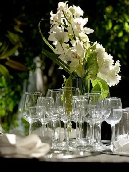 The art of tablescaping is central to our service. Here, an elegant arrangement of fine glassware, custom napkin rings, and fresh floral centerpieces sets the stage for an unforgettable sit-down dinner. We ensure every place setting is perfect.