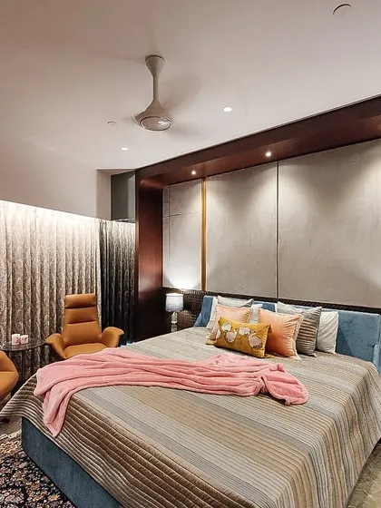 The master bedroom in the Jesrani Residence, designed as a serene retreat. We used a soft, upholstered headboard, warm accent lighting, and rich textiles to create a comfortable and sophisticated space for rest and relaxation.