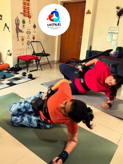 Two clients perform a side plank variation, a challenging core exercise that builds stability and tones the obliques.