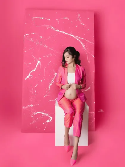 This portrait captures a moment of quiet confidence. The bold pink suit and matching heels create a powerful and fashionable statement.