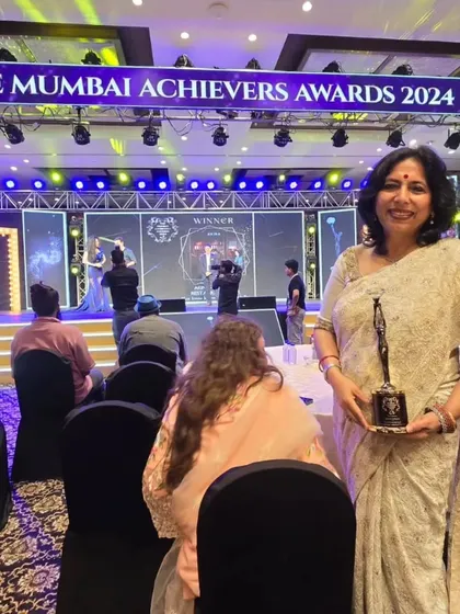 At my table at the Mumbai Achievers Awards 2024, holding the trophy for 'Excellence in Legal & Promising Lawyer of the Year'.
