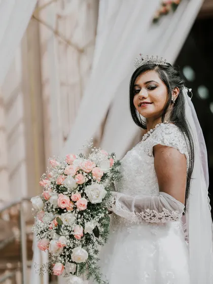 A lovely portrait of the bride and her bouquet, with a soft smile and elegant pose.