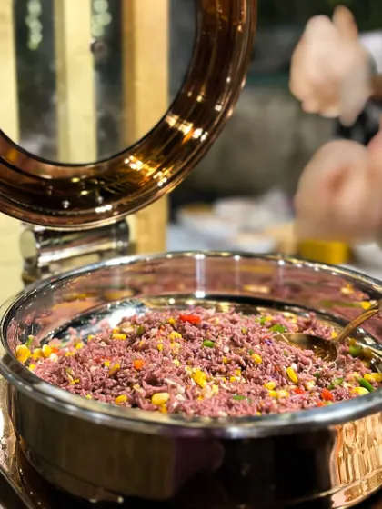 A large serving of my Purple Rice with Paprika Sauce in a copper chafing dish. The unique color from butterfly pea flowers makes it a visual highlight on any buffet line.