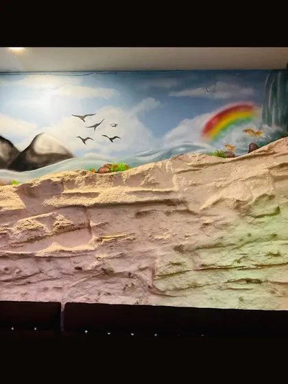 The other side of the panoramic mural, featuring a rainbow and more of the flowing river. The goal was to create a peaceful and scenic view for the restaurant's patrons.