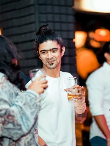 A shot of the crowd mingling and enjoying their drinks during a Saturday night party.