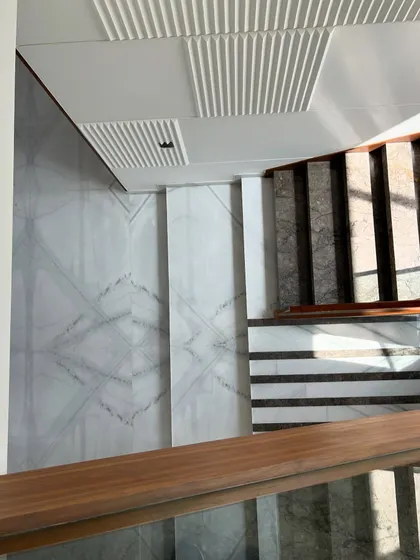A top-down view showing the geometric patterns of the marble flooring at Gulmohar Farmhouse, demonstrating a meticulous attention to detail in even the transitional spaces.