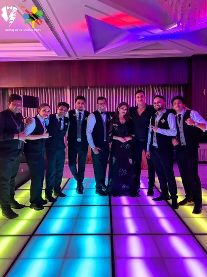 The team posing with clients on a colorful LED dance floor, fully integrated into the party atmosphere.