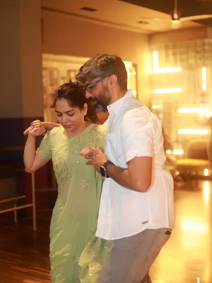 A woman in a beautiful green saree dancing with her partner. It shows that you can come as you are and enjoy the night in any attire.