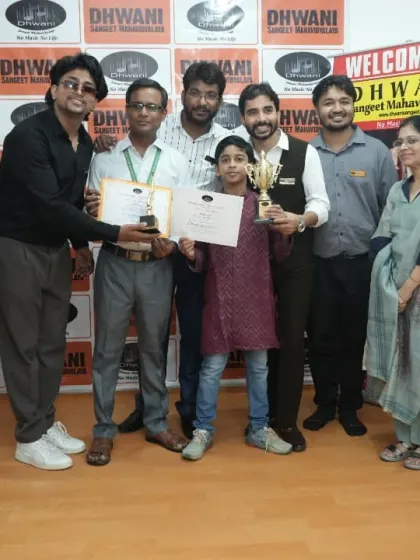 A group photo of teachers and family celebrating a student's success.