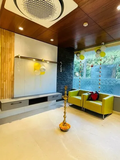 The living room setup at the Indiranagar Experience Center, complete with a sleek TV unit, comfortable seating, and large windows.