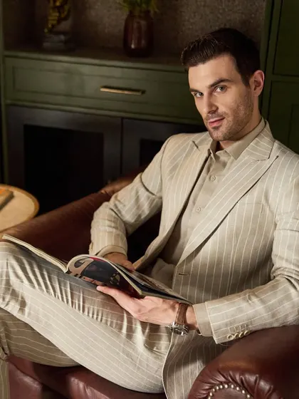 A moment of leisure in the pinstripe linen suit. It's proof that powerful dressing can also be comfortable. The breathable fabric makes it ideal for all-day wear.