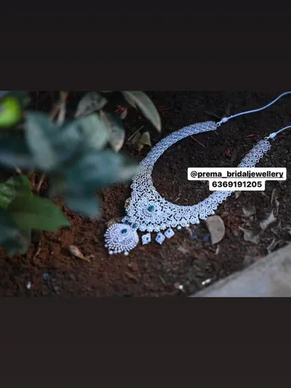 An artistic shot of a beautiful AD and emerald necklace.