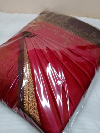 This red saree is pleated and packed, ready for delivery. You can send your sarees to me via a delivery app and get them back like this, ready to go.