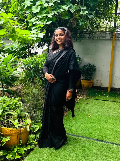 A full-length look at my black saree ensemble for an evening function. My style is a mix of classic and contemporary, and I believe that as your host, my appearance should complement the elegance and vibe of your special event.