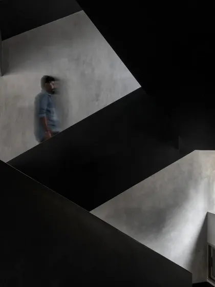 A person ascends the staircase in the Brick House, illustrating the dynamic and experiential nature of the circulation spaces we design.