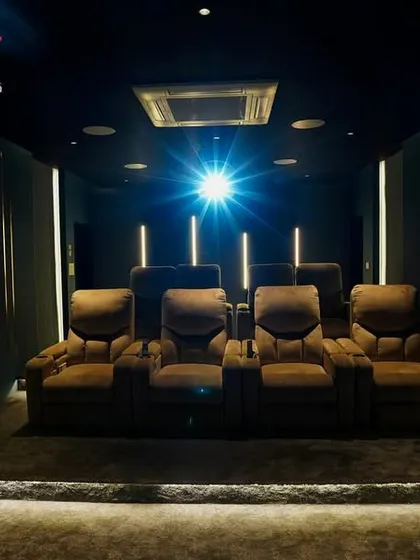 With the lights dimmed, the projector beam illuminates the room, creating a dramatic and authentic cinema-like atmosphere before the movie begins.