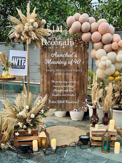 A daytime view of the welcome sign, showing the neutral and blush tones of the balloon garland and the details of the floral arrangements.