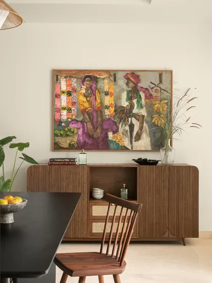 Art is not just decoration; it defines a space. In this dining area, a powerful artwork from JS Mani’s Badami Series becomes the focal point. I designed the custom fluted sideboard and selected the dining furniture to complement the painting's earthy hues and vibrant energy, creating a sophisticated space for gatherings.