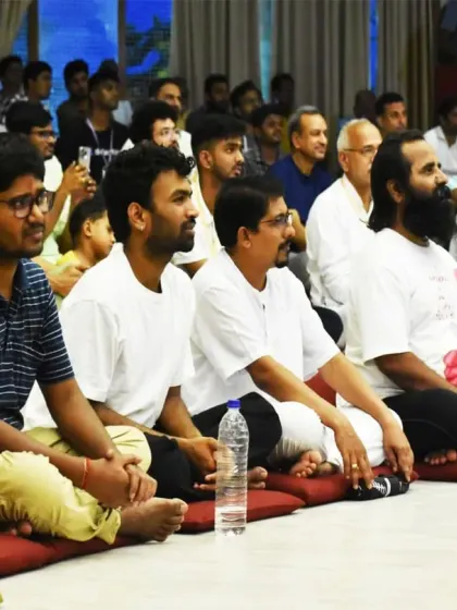 Participants, including families with young children, sit together during a satsang. Volunteering opportunities are available for everyone who wishes to contribute their time and skills.