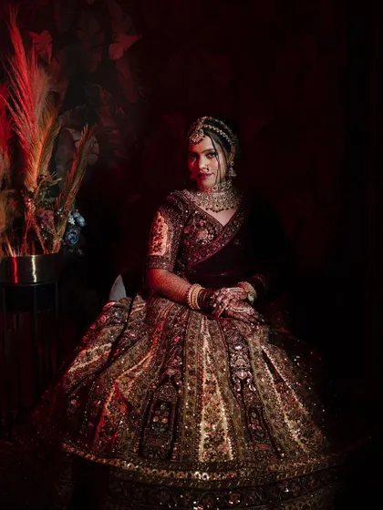 A classic, formal portrait of the bride seated, looking directly at the camera with a confident and poised expression.