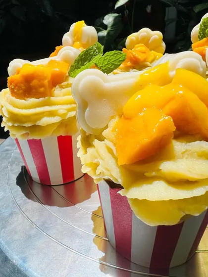 A close-up of the Mango Tango pupcakes, showing the creamy frosting and the handmade jelly bone decoration.