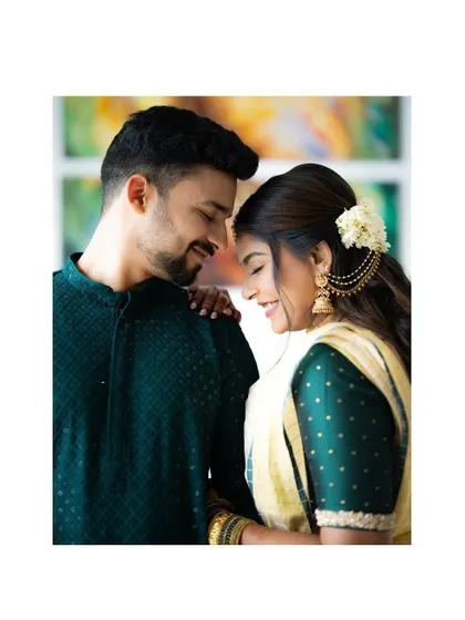A tender moment between an engaged couple. The soft smiles and gentle touch create a feeling of warmth and love.