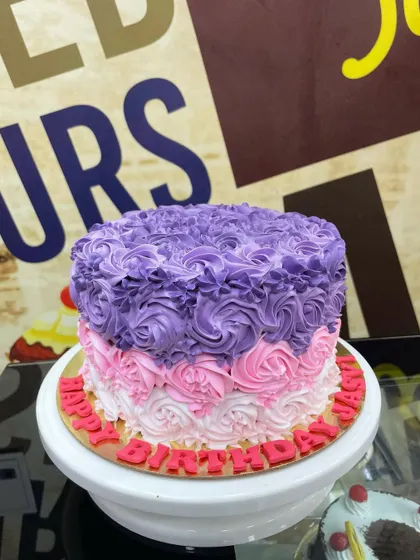 A 1.5kg cake covered in beautiful ombre rosettes, transitioning from white to pink to purple.
